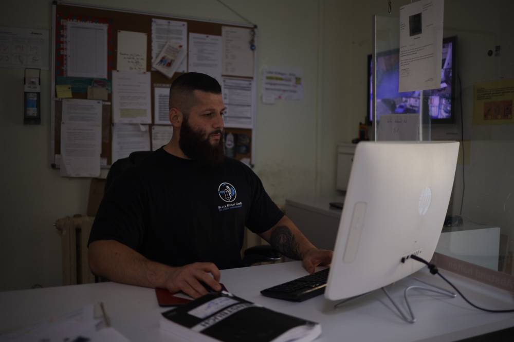 Ein Sicherheitsmitarbeiter sitzt vor einem PC und pflegt Daten zu Vorkommnissen des Tages in einem Objekt in Halle (an der Saale) in ein digitales Wachbuch ein. Er ist im Objektschutz tätig.