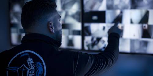 Sicherheitskraft im Pfortendienst Leipzig kontrolliert Monitore der Überwachungskameras